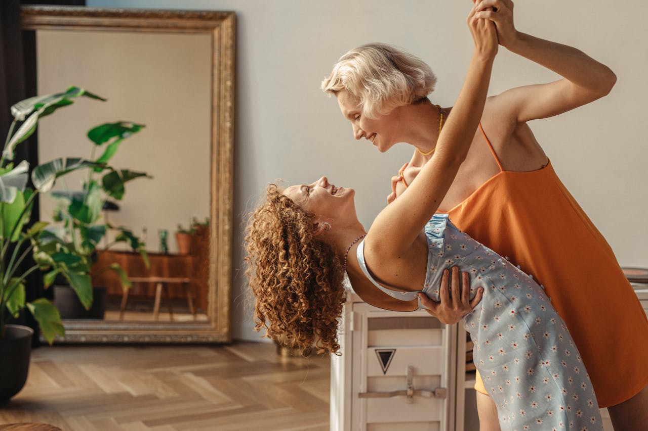 Happy couple sharing a joyful dance in a cozy indoor setting, radiating love and happiness.